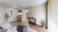 Located in Arlington, TX, this well-designed one-bedroom, one-bathroom residence offers a smart and functional layout across a single floor. The open-concept living and kitchen area serves as the heart of the unit, where hardwood-style flooring flows throughout, creating a cohesive and clean aesthetic. The living room is bright and welcoming, featuring a large sliding glass door fitted with vertical blinds that invite natural light and provide a view of the outdoors. The kitchen is efficiently laid out with warm wood cabinetry, a tile backsplash in a classic diamond pattern, light stone countertops, and black appliances including a range and refrigerator. A breakfast bar with seating connects the kitchen to the living space, adding both utility and a casual dining option. The bedroom offers a comfortable retreat, featuring mirrored sliding closet doors that enhance the sense of space, windows with horizontal blinds for natural light control, and the same hardwood-style flooring. A textured ceiling is consistent throughout the unit. The bathroom includes a vanity with wood cabinetry and stone countertop, along with a full tub-shower combination finished in white tile. Overall, the unit presents a practical and tidy living environment suitable for individuals or couples.