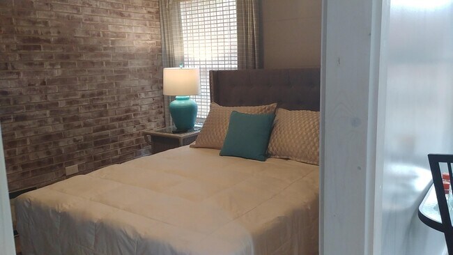 Dormitorio con paredes de ladrillo encalado y ventilador. - 58 Larose Dr SW