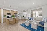 This thoughtfully designed 2-bedroom, 2-bathroom residence offers a bright and cohesive living experience across a single floor. Light wood-style flooring runs throughout the main living areas, complementing a neutral color palette that enhances the sense of openness throughout.

The living room serves as the heart of the home, featuring a large window that invites ample natural light and provides an airy atmosphere. The dining area sits adjacent, also benefiting from generous window placement and sheer drapery that softens the light-filled space.

The kitchen is equipped with light wood cabinetry, white quartz countertops, a subway tile backsplash, and stainless steel appliances including a range, microwave, and dishwasher — offering both style and functionality. Tall pantry-style cabinetry provides substantial storage.

Both bedrooms are carpeted for comfort and feature windows with natural light. The primary bedroom offers a spacious layout with room for a full bedroom suite. Each bathroom is finished with wood-toned vanities, white quartz countertops, and wood-look flooring. The primary bath features a long vanity with dual sinks and a tub-shower combination, while the second bath mirrors the clean, modern aesthetic.

The unit also includes a balcony, a closet, and two hallways connecting the spaces efficiently. A staircase is also present within the layout.