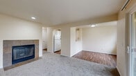 Located at 421 85th Pl SW in Everett, WA, this one-bedroom, one-bathroom unit offers a thoughtfully laid-out single-floor plan. The living room serves as the heart of the home, featuring plush wall-to-wall carpeting, a tile-surround fireplace with glass doors, and a sliding glass door that opens onto a private balcony with views of surrounding trees. A baseboard heating system runs along the living room wall, ensuring year-round comfort. The space transitions seamlessly into a dedicated dining or flex area with warm wood-look vinyl flooring, which connects to the galley-style kitchen. The kitchen is outfitted with white cabinetry, light countertops, a stainless steel sink, and a full suite of white appliances including a refrigerator, electric range, and dishwasher. The bedroom is a comfortable retreat with soft carpeting, a window with natural light, a closet, and the added convenience of an in-unit stacked washer and dryer. The bathroom features wood-look vinyl flooring, a single-sink vanity, a toilet, and a full soaking tub with shower. Neutral tones throughout create a clean, move-in-ready aesthetic.