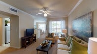 This single-story residence offers two bedrooms and two full bathrooms within a thoughtfully designed floor plan. The living room serves as the central gathering space, featuring crown molding, a ceiling fan with light kit, and neutral carpet flooring. Multiple windows dressed with sheer curtains invite natural light and provide outdoor views, creating a bright and welcoming atmosphere. The layout opens toward a dedicated dining area, which is illuminated by a pendant light fixture and framed by a large window.

The galley-style kitchen is efficiently arranged with warm wood cabinetry, laminate countertops, tile flooring, and a full suite of white appliances including a range, microwave, refrigerator, and dishwasher. Ample upper and lower cabinet storage maximizes functionality throughout.

Each bedroom offers carpeted flooring, a ceiling fan, and generous natural light from oversized windows. Walk-in closet space is present in at least one bedroom, providing practical storage. Both bathrooms feature tile flooring, wood-toned vanity cabinetry with countertop storage, a tub-shower combination, and wall-mounted cabinetry for additional organization. The overall aesthetic throughout the residence is warm and neutral, with consistent finishes creating a cohesive and comfortable environment.