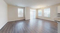 Located at 2470 Merchant Street in Frederick, Maryland, this single-floor residence offers a thoughtfully designed layout with a clean, contemporary aesthetic throughout. The open-concept kitchen is a standout feature, equipped with stainless steel appliances including a refrigerator, range, microwave, and dishwasher. White shaker-style cabinetry, granite countertops, a tiled backsplash, and a central island provide both style and functionality, all complemented by rich hardwood-style flooring that extends into the living and dining areas. The living and dining spaces are generously sized, flooded with natural light from multiple large windows fitted with vertical blinds, and accented by a pendant light fixture. The bedrooms feature plush carpeting, ample natural light, and neutral tones. At least one bedroom includes a walk-in closet with built-in shelving. The primary bathroom offers a standalone shower with sliding glass doors, a white vanity with under-cabinet storage, and large-format tile flooring. A second bathroom features a full soaking tub and shower combination alongside a white vanity. Throughout the residence, neutral warm tones, crisp white trim, and consistent finishes create a bright, move-in-ready environment.