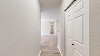 Located at 2175 Stockwell Rd in Bossier City, Louisiana, this single-story, three-bedroom, two-bathroom home offers a well-designed layout with consistent light wood-look flooring throughout. The open kitchen is a standout feature, equipped with white shaker-style cabinetry, granite countertops, a breakfast bar peninsula, and stainless steel appliances including an electric range, microwave, and refrigerator. The adjacent living area provides an open, connected feel ideal for everyday living.

Each of the three bedrooms is finished with the same light wood-look flooring, neutral-toned walls, and ceiling fans with lighting. The bedrooms receive natural light through windows fitted with horizontal blinds. The spacious primary bedroom includes a walk-in closet outfitted with wire shelving systems, and additional closets throughout the home offer generous storage.

The bathrooms are finished with white cabinetry, granite countertops with undermount sinks, and tub-shower combinations. A dedicated laundry room accommodates a full-size washer and dryer with overhead wire shelving for added convenience.

A central hallway connects the bedrooms and common areas, giving the home a practical, organized flow. Clean white walls, modern hardware, and cohesive finishes throughout create a fresh, move-in-ready atmosphere.