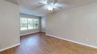 This single-floor, 2-bedroom, 2-bathroom residence offers a practical and comfortable layout designed to maximize everyday living. The open-concept kitchen and living area serves as the heart of the home, featuring warm hardwood-style flooring, a textured ceiling, and a ceiling fan with integrated lighting. A large window invites abundant natural light, creating a bright and welcoming atmosphere. The kitchen is equipped with rich honey-toned wood cabinetry, a full suite of white appliances including a range, microwave, and refrigerator, and a peninsula with a laminate countertop and stainless steel sink — ideal for casual dining or meal prep. Both bedrooms are finished with plush wall-to-wall carpeting, ceiling fans, and windows that bring in natural light. The primary bedroom offers a generous footprint with direct access to its own bathroom. Each of the two bathrooms features a full tub-and-shower combination with white tile surround, chrome fixtures, and hardwood-style flooring. A dedicated laundry room houses a full-size washer and dryer with an overhead storage shelf, adding everyday convenience. Two closets provide ample storage throughout. Neutral-toned walls and consistent finishes lend a cohesive, move-in-ready feel to the entire space.