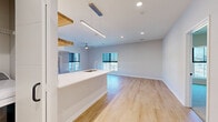 This contemporary 2-bedroom, 2-bathroom residence at 5395 Martway St in Mission, Kansas, offers a thoughtfully designed single-floor layout with clean lines and modern finishes throughout. The open-concept kitchen and living area serves as the heart of the home, featuring a large white quartz peninsula with an undermount sink, sleek white cabinetry, stainless steel appliances including a refrigerator, range, and microwave, a subway tile backsplash, and warm natural wood floating shelves that add character. Pendant lighting accents the kitchen, while recessed lighting and a ceiling fan illuminate the expansive living area, which is bathed in natural light from multiple windows. Light-toned hardwood flooring flows seamlessly throughout the main living spaces, enhancing the bright, airy ambiance. The spacious primary bedroom offers a generous footprint, a ceiling fan, natural light from a large window, and access to a walk-in closet outfitted with wire shelving systems for ample storage. The second bedroom is equally well-appointed with plush carpet, a ceiling fan, and a large window with exterior views. Both bathrooms are finished with clean, contemporary fixtures. A second closet provides additional storage. The overall aesthetic is fresh, modern, and move-in ready.