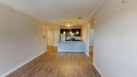 Located at 800 Wolf Ranch Parkway in Georgetown, TX, this single-story residence offers four bedrooms and two bathrooms across a well-designed floor plan. The open-concept living and kitchen area serves as the heart of the home, featuring warm wood-look flooring, crown molding, and an airy, connected feel. The kitchen is outfitted with dark espresso cabinetry, granite countertops, a subway tile backsplash, stainless steel appliances, and a peninsula with pendant lighting overhead — ideal for both cooking and casual dining. The living area is bright and spacious, with natural light streaming in through windows and a glass-paned exterior door. Each of the four bedrooms is carpeted for comfort and equipped with a ceiling fan and window with blinds, allowing for natural light and ventilation. The primary bedroom offers a generous footprint. The bathrooms feature neutral tile flooring, and at least one includes a classic soaking tub and shower combo with white subway tile surround and brushed nickel fixtures. A dedicated hallway and closet provide practical storage solutions. Neutral, warm-toned walls throughout the home create a cohesive and welcoming ambiance suitable for a variety of lifestyles.
