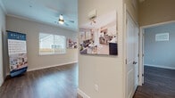 This single-story residence is designed with high-end finishes and an open, functional layout. Throughout the home, warm hardwood-style flooring flows seamlessly, complemented by crisp white baseboards and neutral-toned walls that create a clean, inviting atmosphere. The soaring 10-foot ceilings, accented by crown molding, add a sense of spaciousness and airiness to every room, while ceiling fans provide both comfort and style.

The kitchen serves as a central highlight, showcasing granite countertops, sleek gray shaker-style cabinetry, and a full suite of stainless steel appliances, including a refrigerator with ice maker, electric range, built-in microwave, and dishwasher. A white subway tile backsplash adds a contemporary touch, and a peninsula provides additional prep and seating space. Natural light fills the kitchen through multiple windows and a sliding glass door that opens directly to a private backyard.

The living areas are generously proportioned, with recessed lighting and ample room for flexible use. The bathroom features granite countertops, gray cabinetry, wood-look flooring, and a walk-in shower with a glass door. The home combines modern design with practical finishes throughout.