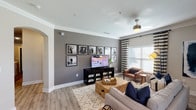 Located on Meadow Ranch Pkwy in Richmond, TX, this single-story residence showcases a thoughtfully designed interior with contemporary finishes throughout. The open-concept living area features warm wood-look flooring, crown molding, and large windows dressed with striped drapery panels that allow ample natural light to fill the space. A ceiling fan anchors the room, and a neutral color palette is complemented by bold accent decor.

The kitchen is well-equipped with dark espresso cabinetry, granite countertops, a subway tile backsplash, stainless steel appliances including a refrigerator, range, and built-in microwave. Track lighting and an adjacent exterior door enhance the functional layout.

The bedrooms offer a refined, tranquil atmosphere. The primary bedroom features an accent wall with decorative wallpaper, a ceiling fan, and windows with floor-length drapery. Bathrooms are finished with granite vanities, wood-look flooring, and include both a tub/shower combination and a separate glass-enclosed walk-in shower, providing distinct options for comfort and convenience.