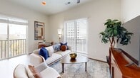 Located in the heart of uptown Charlotte on N. Tryon Street, this 2-bedroom, 3-bathroom residence offers a thoughtfully designed single-floor layout. Rich hardwood flooring runs throughout, complementing the bright, neutral palette that defines the space's modern aesthetic.

The open-concept kitchen, dining, and living area forms the heart of the home. The kitchen is outfitted with crisp white shaker cabinetry extending to the ceiling, a classic subway tile backsplash, stainless steel appliances including a full suite of range, microwave, dishwasher, and refrigerator, and light quartz countertops. A sliding glass door in the dining area connects to an outdoor balcony with city views. The living room benefits from large windows offering urban vistas and features a ceiling fan for added comfort.

A hallway adorned with bold, oversized wall art connects the living areas to the private quarters. The primary bedroom is a serene retreat with a walk-in closet and natural light from a window overlooking the cityscape. Two additional bathrooms serve the residence, including one with a soaking tub and white tile surround. A dedicated closet provides additional storage. The overall ambiance is clean, contemporary, and well-suited for urban living.