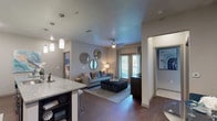 This well-appointed 2-bedroom, 2-bathroom single-floor residence offers a thoughtfully designed open-concept layout that seamlessly connects the kitchen, dining, and living areas. The kitchen is a standout feature, showcasing bold dark cabinetry, granite countertops, a large peninsula with bar seating, pendant lighting, a mosaic tile backsplash, and a full suite of stainless steel appliances. Wood-style plank flooring flows throughout the main living areas, adding warmth and continuity.

The living room is bright and inviting, with a ceiling fan, large windows and sliding glass doors that bring in natural light and outdoor views. Both bedrooms are generously sized, featuring plush carpeting, ceiling fans, and large windows. The primary bedroom connects to a well-sized en-suite bathroom complete with a dual-sink granite vanity, a glass-enclosed walk-in shower, and a spacious walk-in closet. The second bathroom mirrors the same quality finishes, offering a dual-sink granite vanity and ample counter space. An in-unit laundry area rounds out the functional layout of this modern, move-in-ready residence.