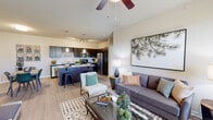 Located in Colorado Springs, CO, this single-floor residence offers a thoughtfully designed open-concept layout that seamlessly connects the living, dining, and kitchen areas. The living room features light hardwood-style flooring, a ceiling fan, and large windows fitted with blinds that invite abundant natural light. A bold nature-inspired wall print adds a distinctive artistic touch to the space.

The kitchen is a standout feature, showcasing rich dark cabinetry, granite-look countertops, a large central island with bar seating, and a full suite of stainless steel appliances including a refrigerator, range, and microwave. Track lighting overhead and pendant lights above the island complete the polished look.

The bedrooms offer plush carpeting, ceiling fans, and generous natural light through double windows. Each room provides a calm, restful atmosphere with neutral tones throughout.

The bathroom includes a full tub-and-shower combination with a curved curtain rod, granite-topped vanity, and light hardwood-style flooring. A dedicated in-unit laundry closet houses a full-size side-by-side washer and dryer, adding everyday convenience. Overall, the residence presents a clean, contemporary aesthetic well-suited to modern living in Colorado Springs.
