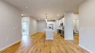 Located at 1211 Carrington Blvd in Mount Pleasant, WI, this single-story home spans 1,380 square feet and features 3 bedrooms, 2 bathrooms, and an attached garage. The open-concept kitchen and living area serves as the heart of the home, showcasing white shaker cabinetry, quartz countertops, a large center island with an undermount sink, stainless steel appliances, and light hardwood flooring throughout. Recessed lighting illuminates the space with a clean, modern aesthetic. The living room features large glass-paneled entry doors that invite abundant natural light and provide outdoor views. The primary bedroom measures 170 square feet and is carpeted, with multiple windows offering natural light. The additional bedrooms are similarly appointed with plush carpet and window treatments. Both bathrooms feature gray shaker-style vanities with white countertops and matte black hardware; one includes a full tub-shower combo with a tall linen tower cabinet. Three closets provide ample storage throughout. The attached garage features a concrete floor and an automatic opener. Neutral tones and contemporary finishes create a cohesive, move-in-ready atmosphere throughout the home.