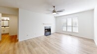 Located at 8000 Waters Ave in Savannah, Georgia, this single-story, 2-bedroom, 1-bathroom home offers a practical and comfortable layout across a well-utilized floor plan. The living room serves as the heart of the home, featuring light hardwood-style flooring, a classic fireplace with a white mantle, a ceiling fan, and a large window that fills the space with natural light. Adjacent to the living area, the kitchen is outfitted with white cabinetry, stainless steel appliances, and a peninsula countertop with a matte black faucet and undermount sink, creating an open and functional cooking space. Both bedrooms are carpeted and bright, each featuring multiple windows with blinds that allow for ample natural light. The generously sized primary bedroom offers notable square footage for comfortable furnishing. The bathroom includes a wide white vanity countertop, a large framed mirror, and matte black fixtures. A dedicated laundry room with full-size washer and dryer adds everyday convenience. The home also features a sunroom with vertical wood-paneled walls, a ceiling light, and large windows overlooking lush greenery — a charming bonus space unique to the property.