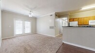 Located at 4106 John Stockbauer Dr in Victoria, Texas, this single-story home offers four bedrooms and two full bathrooms across a well-utilized floor plan. The living area is bright and welcoming, featuring crown molding, a ceiling fan with light fixture, plush carpet, and durable hardwood-style flooring at the entry. French doors allow natural light to fill the space, creating an open and airy ambiance. The kitchen is efficiently designed with warm oak cabinetry, dark countertops, hardwood-style flooring, and white appliances including a refrigerator, electric range, and built-in microwave. A hallway connects the main living areas to the four carpeted bedrooms, each equipped with ceiling fans and ample natural light through window blinds. The primary bedroom includes access to a spacious walk-in closet with wire shelving and a private en-suite bathroom. The primary bath features tile flooring, a single-sink vanity with dark countertops, a tub-shower combination with tile surround, and an adjacent walk-in closet. The second full bathroom mirrors this design with a tub-shower combo, tile floors, and a matching vanity. Additional bedroom closets offer built-in shelving for organized storage throughout.
