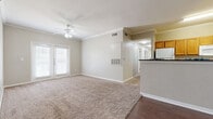 Located at 4106 John Stockbauer Dr in Victoria, Texas, this single-story home offers four bedrooms and two full bathrooms across a well-utilized floor plan. The living area is bright and welcoming, featuring crown molding, a ceiling fan with light fixture, plush carpet, and durable hardwood-style flooring at the entry. French doors allow natural light to fill the space, creating an open and airy ambiance. The kitchen is efficiently designed with warm oak cabinetry, dark countertops, hardwood-style flooring, and white appliances including a refrigerator, electric range, and built-in microwave. A hallway connects the main living areas to the four carpeted bedrooms, each equipped with ceiling fans and ample natural light through window blinds. The primary bedroom includes access to a spacious walk-in closet with wire shelving and a private en-suite bathroom. The primary bath features tile flooring, a single-sink vanity with dark countertops, a tub-shower combination with tile surround, and an adjacent walk-in closet. The second full bathroom mirrors this design with a tub-shower combo, tile floors, and a matching vanity. Additional bedroom closets offer built-in shelving for organized storage throughout.