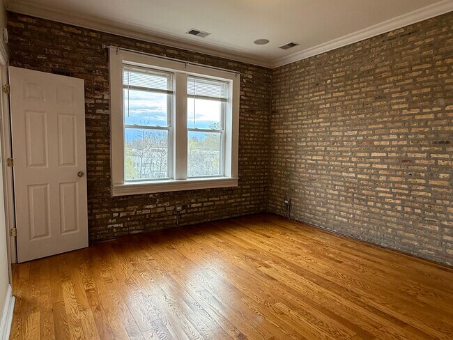 Primary Bedroom with exposed Brick - 6150 N Ravenswood Ave