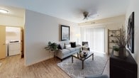 This single-floor residence offers a thoughtfully designed layout that balances comfort and functionality throughout its living spaces. The kitchen is outfitted with rich, warm-toned cabinetry, granite countertops, and a full suite of stainless steel appliances, including a range, microwave, dishwasher, and refrigerator, all set atop wood-look flooring that extends into the living area.

The living room provides a welcoming, open atmosphere with the same wood-look flooring, a ceiling fan overhead, and a sliding glass door fitted with vertical blinds that invites natural light into the space. The bedroom features plush carpeting, a ceiling fan, natural light from a sliding window, and ample room for furnishings. A second carpeted room with a ceiling fan and open window serves well as a home office or additional bedroom, complete with space for a desk and seating area.

Two full bathrooms serve the residence. One features a combination tub and shower with a curtain rod, granite-topped vanity with warm wood cabinetry, and tile flooring. The second bathroom echoes similar finishes, with a granite vanity, wood cabinetry, a lighted mirror, and patterned tile flooring at the entry. Together, the spaces create a cohesive, comfortable living environment.