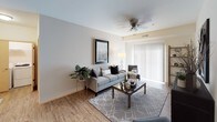 This single-floor residence offers a thoughtfully designed layout that balances comfort and functionality throughout its living spaces. The kitchen is outfitted with rich, warm-toned cabinetry, granite countertops, and a full suite of stainless steel appliances, including a range, microwave, dishwasher, and refrigerator, all set atop wood-look flooring that extends into the living area.

The living room provides a welcoming, open atmosphere with the same wood-look flooring, a ceiling fan overhead, and a sliding glass door fitted with vertical blinds that invites natural light into the space. The bedroom features plush carpeting, a ceiling fan, natural light from a sliding window, and ample room for furnishings. A second carpeted room with a ceiling fan and open window serves well as a home office or additional bedroom, complete with space for a desk and seating area.

Two full bathrooms serve the residence. One features a combination tub and shower with a curtain rod, granite-topped vanity with warm wood cabinetry, and tile flooring. The second bathroom echoes similar finishes, with a granite vanity, wood cabinetry, a lighted mirror, and patterned tile flooring at the entry. Together, the spaces create a cohesive, comfortable living environment.