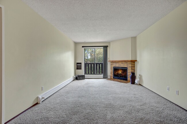 A living room with fireplace and large sliding glass doors - Forest Grove Village