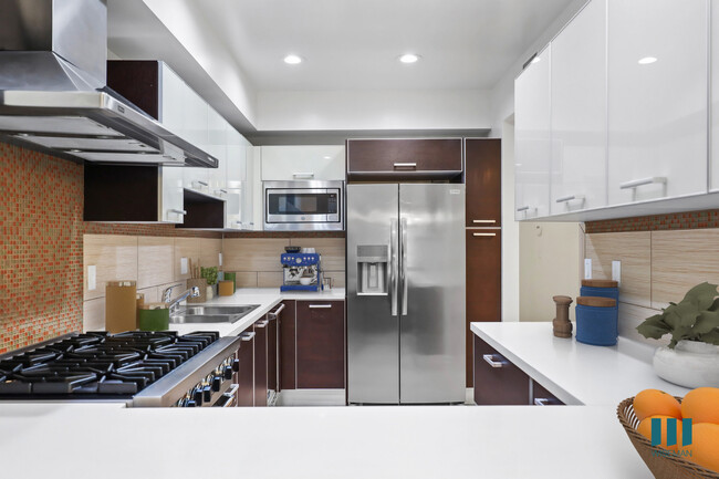 Kitchen with Stainless-Steel Appliances and Countertop Bar - Sweetzer on Third