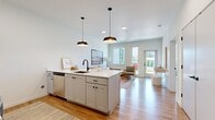 Located at 7900 SE Luther Road in Portland, Oregon, this efficiently designed 500-square-foot, single-floor unit offers 2 bedrooms and 1 bathroom. Light hardwood-style flooring flows throughout, complementing the clean, white walls that give the space a bright and airy feel.

The open-concept kitchen is a standout, featuring white shaker cabinetry, stainless steel appliances including a range, microwave, and refrigerator, a white quartz island with a matte black faucet, and pendant lighting overhead. The adjacent living room receives abundant natural light through large windows and a glass door that opens directly to the outdoors, creating a seamless indoor-outdoor connection.

The primary bedroom measures 110 square feet and features large windows overlooking lush greenery, providing a serene retreat. It includes a walk-in closet and convenient access to the full bathroom. The second bedroom is compact and well-lit, with direct sightlines to the kitchen. The shared bathroom offers a navy shaker-style vanity with a white quartz countertop, a full soaking tub with shower, and hardwood-style flooring. The unit combines modern design with functional, efficient use of space.