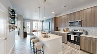 Located at 608 Sahwatch St in Colorado Springs, CO, this single-floor unit offers a thoughtfully designed open-concept layout. The combined kitchen and living area serves as the heart of the space, where contemporary design meets everyday functionality. The kitchen is appointed with wood-grain cabinetry extending to the ceiling, stainless steel appliances, a classic subway tile backsplash, quartz countertops, and a generous island with an integrated sink and bar seating illuminated by stylish pendant lighting. Light wood-style flooring runs throughout, enhancing the bright and airy feel. The living area features a bold accent wall, large windows, and a private balcony door that invites an abundance of natural light and outdoor views. The walk-in closet is outfitted with wire shelving and hanging rods along multiple walls, offering well-organized storage on plush carpeting. The bathroom is elegantly finished with large-format tile flooring, a lengthy dual-sink vanity with wood-tone cabinetry and quartz countertops, a soaking tub, and a separate walk-in shower. Neutral tones and clean lines throughout the space create a cohesive, modern aesthetic well-suited to Colorado Springs living.