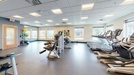 Located at 2448 Winnetka Ave N in Golden Valley, Minnesota, this fitness center offers a comprehensive workout facility spread across a single, open floor. The space is thoughtfully organized into distinct exercise zones, allowing users to seamlessly transition between different types of training.

The cardio area is lined with modern treadmills and elliptical machines positioned along windowed walls, allowing natural light to fill the space and providing views of the surrounding neighborhood. A dedicated strength training zone features a robust selection of selectorized machines, a cable system, and a full dumbbell rack, catering to a wide range of resistance training needs.

A separate functional training area is appointed with exercise balls, medicine balls, resistance tools, and workout mats, making it ideal for flexibility, balance, and dynamic movement exercises. Floor-to-ceiling mirrors in this zone enhance the sense of space and allow for form monitoring during workouts.

Throughout the facility, durable speckled rubber flooring provides safety and comfort underfoot, while a drop ceiling with recessed panel lighting ensures consistent, well-distributed illumination. The warm accent walls and clean, neutral tones contribute to an energizing yet focused atmosphere, making this fitness center a well-rounded amenity for the Golden Valley community.
