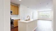 Located at 40 East Hanover Avenue in Morris Plains, NJ, this well-appointed 2-bedroom, 2-bathroom residence offers a thoughtfully designed single-floor layout. Wood-style flooring runs throughout the home, providing a warm and cohesive aesthetic. The open-concept living and dining area is bright and spacious, with large windows that invite generous natural light and offer outdoor views, alongside a glass-panel door that extends the sense of openness. The kitchen is a standout feature, anchored by a peninsula with a white quartz countertop and a gold-finish faucet with an undermount sink. Warm-toned wood cabinetry lines the walls, complemented by a herringbone tile backsplash and stainless steel appliances, including a range, microwave, and refrigerator. A pantry provides additional storage convenience. Both bedrooms are well-sized, each featuring wood-style flooring and large windows that fill the rooms with natural light. The two bathrooms are finished with white tile tub-and-shower combinations accented by a mosaic tile border, paired with wood-style flooring. Additional features include four closets, an in-unit laundry, a hallway, and a utility room, ensuring practical everyday functionality throughout the home.