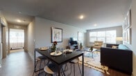 This single-floor residence is thoughtfully designed with a functional, open layout that connects the main living spaces seamlessly. An entry hallway with a built-in HVAC unit leads into the heart of the home, where the kitchen, dining, and living areas flow naturally into one another.

The kitchen is outfitted with dark espresso cabinetry, granite-style countertops, stainless steel appliances including an electric range, over-the-range microwave, and dishwasher, providing a practical and stylish workspace. Adjacent to the kitchen, the dining area accommodates a full-sized table with barstool seating, making it ideal for both everyday meals and entertaining.

The living room is bright and welcoming, with large windows allowing ample natural light and views of the surrounding neighborhood. Wood-style plank flooring runs throughout the main areas, adding warmth and visual continuity.

The unit includes two bedrooms, each carpeted and featuring windows with outdoor views. One bedroom offers a dedicated desk area, while both provide comfortable proportions and closet access. Two bathrooms mirror each other in layout, each with wood-style flooring, a shower-tub combination, and clean, neutral finishes. The overall ambiance is modern, comfortable, and move-in ready.