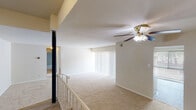 This single-floor residence is thoughtfully laid out with a distinctive split-level design, where a few steps and a railed landing separate the entry area from the main living space. The spacious living room features plush wall-to-wall carpeting, neutral-toned walls, and a ceiling fan with integrated lighting. A large vertical-blind window treatment allows for ample natural light to fill the room, creating a bright and welcoming atmosphere.

The bedrooms continue the carpeted flooring theme, each offering generous proportions and windows fitted with horizontal blinds that provide both privacy and light control. The rooms are finished with clean white trim and neutral walls, offering a versatile backdrop for a variety of furnishing styles.

The kitchen is equipped with light wood cabinetry, dark granite-style countertops, a gas range, a dishwasher, and a stainless steel sink — providing a practical and well-appointed cooking space. Tile-style flooring adds durability to this area.

Two bathrooms serve the unit, each featuring wood-toned vanity cabinetry, white countertops, mirrors with overhead lighting, and wood-look vinyl flooring. One bathroom includes a tub-shower combination, while the other offers a well-lit dual-mirror vanity setup. Throughout, the space maintains a clean, functional aesthetic suited for comfortable everyday living.