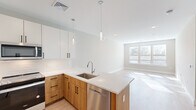 This contemporary 850 square foot apartment in Langhorne, PA, offers a harmonious blend of style and functionality. The open-concept design seamlessly integrates the kitchen and living areas, creating a spacious feel. The kitchen is a highlight, featuring two-tone cabinetry with light upper cabinets and warm wood lower cabinets, complemented by stainless steel appliances and a striking white quartz countertop with a waterfall edge on the island.

Large windows throughout flood the space with natural light, enhancing the airy atmosphere. The two bedrooms are generously sized, with the primary bedroom boasting 150 square feet. The bathroom showcases modern fixtures and a floating vanity, maintaining the sleek aesthetic of the home.

Light-toned wood-look flooring unifies the space, while neutral wall colors provide a versatile backdrop. The dedicated laundry area adds convenience, and multiple closets offer ample storage. The apartment's single-floor layout ensures easy accessibility, making it an ideal choice for various lifestyles. Located at 200 Middletown Blvd, this apartment combines urban sophistication with suburban comfort.
