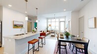 This thoughtfully designed 2-bedroom, 2-bathroom residence combines modern aesthetics with functional living across a single floor. The open-concept living, dining, and kitchen area serves as the heart of the home, featuring light hardwood flooring and an abundance of natural light streaming through oversized windows with outdoor views. The kitchen is appointed with white shaker cabinetry, granite countertops, stainless steel appliances, a built-in wine rack, and a central island with bar seating illuminated by pendant lighting. The dining area accommodates a full table and flows seamlessly into the bright living room, which features a textured accent wall and ceiling fan. The primary bedroom is a well-proportioned retreat highlighted by a bold teal accent wall, large window, and light wood flooring. Its en-suite bathroom includes a double-sink vanity with granite countertops, white cabinetry, and a marble-tiled soaking tub. The second bedroom shares the home's clean, modern palette. Two dedicated closets provide ample storage throughout. The overall ambiance is bright, airy, and contemporary, with consistent finishes that lend a cohesive and polished character to every room.