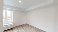 Located at 2551 Commercial Street in San Diego, CA, this efficiently designed single-floor studio presents a clean, contemporary aesthetic throughout. Light wood-tone laminate flooring flows continuously across the entire unit, complementing the crisp white walls and recessed ceiling lighting that keep the space feeling bright and airy.

The open-concept living, dining, and kitchen area forms the heart of the unit. The kitchen is outfitted with white cabinetry, stainless steel appliances including a refrigerator, electric range, and over-the-range microwave, providing full cooking functionality within a compact footprint. A window at the far end of the living area allows natural light to filter in, enhancing the sense of openness.

The closet features a full-width mirrored sliding door, which reflects light and adds a sense of depth to the room. A louvered interior door provides access to additional storage. The bathroom is well-appointed with a full-size soaking tub and tiled shower surround, a vanity with an integrated sink and mirror, and accessibility grab bars thoughtfully installed alongside the toilet and tub. The bathroom also continues the light wood flooring found throughout the rest of the unit, maintaining a cohesive design. Overall, this studio offers a functional and modern living environment in San Diego.