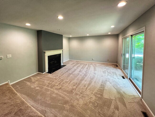 Open livingroom, new carpet, exit to patio - 1250 Park Ave W