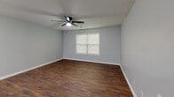 Located at 5310 McAlpine Glen Dr in Charlotte, NC, this single-floor, three-bedroom, two-bathroom home offers a practical and comfortable layout. The kitchen is well-equipped with light maple cabinetry, light-toned countertops, dark hardwood-style flooring, and a full suite of black appliances including a refrigerator, electric range, microwave, and dishwasher, alongside a double-basin stainless steel sink. The combined kitchen and living area creates an open, functional hub for daily living. The spacious primary bedroom features plush carpeting, a ceiling fan, a natural light-filled window, and direct access to an en-suite bathroom. The secondary bedrooms are similarly appointed with carpet flooring, ceiling fans, and windows with blinds that invite natural light. Both bathrooms are finished with hardwood-style flooring and include a full tub-shower combination. Neutral gray walls carry consistently throughout the home, complemented by white trim, creating a clean and cohesive aesthetic. Textured ceilings add a classic touch, while the overall layout provides a straightforward and efficient use of space suitable for a variety of living arrangements.