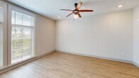 Located in the heart of Charleston's historic East Bay corridor, this well-appointed 2-bedroom, 1-bathroom residence offers a clean, modern aesthetic across a single thoughtfully designed floor. Light wood-style flooring flows throughout the main living areas and kitchen, lending a bright, cohesive feel to the space.

The open-concept kitchen and living room serve as the heart of the home. The kitchen is outfitted with white shaker cabinetry, granite countertops, a subway tile backsplash, and a full suite of stainless steel appliances including a refrigerator, range, microwave, and dishwasher — all set against recessed lighting and generous cabinet storage.

The living area benefits from large windows that invite abundant natural light and views of surrounding greenery, complemented by a ceiling fan overhead.

Both bedrooms are carpeted for comfort and each feature ceiling fans. The primary bedroom offers a comfortable footprint, while both rooms are served by closets with built-in wire shelving for organized storage.

The full bathroom is finished with a granite-topped vanity with dark hardware, a tub-shower combo with tile surround, and wood-look tile flooring. A well-lit hallway with modern paneled doors and recessed lighting connects all rooms seamlessly, completing this clean and functional Charleston residence.