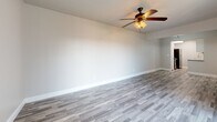 Located at 808 E Sanford St in Arlington, TX, this single-story, 2-bedroom, 2-bathroom home offers a thoughtfully designed layout with modern finishes throughout. The living areas feature wood-look plank flooring in a cool gray tone, neutral painted walls, and ceiling fans with integrated lighting, creating a bright and airy atmosphere. A sliding glass door in one of the living areas floods the space with natural light and provides access to an outdoor area. The galley-style kitchen is well-equipped with granite countertops, white shaker cabinetry, white subway tile backsplash, a double basin sink, and black appliances, all complemented by the same wood-look flooring. Both bathrooms feature wood-look tile flooring, white vanity cabinetry, and a tub-shower combination with large-format gray stone tile surround, offering a clean, contemporary feel. The bedrooms are carpeted for comfort and each includes a ceiling fan and ample closet space — the primary bedroom features a walk-in closet, while the secondary bedroom includes a standard closet. A dedicated hallway connects the rooms efficiently. The cohesive neutral palette and modern material selections throughout give this home a fresh, move-in-ready appeal.