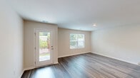 Located at 220 Harvest Gold Dr in Conway, South Carolina, this two-story, 3-bedroom, 3-bathroom home offers a well-organized layout across two floors. The main level houses the kitchen and living room, an attached garage, and a hallway, while the upper floor accommodates the bedrooms and remaining bathrooms. Throughout the home, durable wood-look flooring adds warmth and continuity.

The kitchen is a functional highlight, featuring crisp white shaker-style cabinetry, granite countertops with a peninsula sink, and a full suite of stainless steel appliances including a refrigerator with ice maker, electric range, and over-the-range microwave. Recessed lighting brightens the space efficiently.

The living room is open and bright, with a glass-panel door providing access to the outdoors and natural light throughout. The spacious primary bedroom includes a ceiling fan, wood-look flooring, and access to both a walk-in closet with wire shelving and a private en-suite bathroom featuring a walk-in shower with built-in shelving. The additional bedrooms are well-sized with windows offering outdoor views. Secondary bathrooms include granite-topped vanities, white cabinetry, and shower-tub combinations. The attached garage provides convenient parking and additional storage with a sectional overhead door.