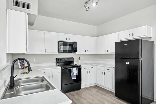 Spacious Kitchen with Black Appliances - The Henry at Deerbrook