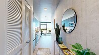 Located in Chicago's vibrant West Loop neighborhood, this thoughtfully designed one-bedroom, one-bathroom unit offers a compelling blend of industrial aesthetics and contemporary finishes. Exposed concrete ceilings contrast beautifully with light wood-style flooring throughout, establishing a modern urban character from the moment you enter.

The open-plan kitchen and living area is anchored by a sleek galley-style kitchen featuring dark upper cabinetry, white lower cabinets, white subway tile backsplash, stainless steel appliances, and a matte black faucet over an undermount sink. The living area flows naturally toward dramatic floor-to-ceiling windows that frame sweeping views of the Chicago skyline and cityscape, flooding the space with abundant natural light.

The bedroom continues the floor-to-ceiling window theme, offering the same impressive city views and an airy, light-filled atmosphere beneath a concrete ceiling. A closet provides practical storage within the compact yet efficiently laid-out room.

The bathroom is finished to a high standard, featuring a floating dark navy vanity with a backlit mirror, a glass-enclosed walk-in shower, and clean light-toned tile flooring, delivering a spa-like feel. Every detail of this unit reflects a precise, modern design sensibility well-suited to urban living.
