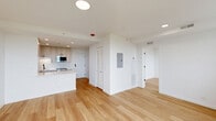 Located along the prestigious North Lincoln Park West corridor in Chicago's Lincoln Park neighborhood, this thoughtfully designed one-bedroom, one-bathroom residence offers a clean, modern aesthetic throughout. Light-toned hardwood flooring runs continuously across the entire floor plan, lending a cohesive and airy feel to every room.

The open-concept kitchen and living area serves as the heart of the home. The kitchen is well-appointed with two-tone shaker-style cabinetry in a warm greige finish, sleek white quartz countertops, a subway tile backsplash, stainless steel appliances including a refrigerator and range, an over-the-range microwave, and a matte black faucet at the sink. A central island with additional cabinetry provides extra prep space and storage.

The living area benefits from a large window framing sweeping views of Lake Michigan and Lincoln Park's lush tree canopy, flooding the space with natural light. The bedroom continues this connection to the outdoors with two generous windows offering the same stunning lakefront and park views.

The bathroom is finished with white subway wall tile, a white vanity with quartz countertop, a bold round mirror with a matte black frame, and globe light fixtures, creating a stylish and modern atmosphere. Recessed lighting throughout the unit completes this bright, contemporary residence.