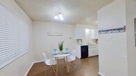 This single-story, one-bedroom, one-bathroom unit offers a thoughtfully organized layout across a comfortable footprint. The open-concept living and dining area is anchored by a textured ceiling, ceiling fan with light fixture, and a bold accent wall, creating a lively yet functional gathering space with carpet underfoot. The adjacent dining nook features wood-look flooring, a window with blinds for natural light, and seamless access to the kitchen.

The kitchen is well-equipped with ample white cabinetry, generous counter space, a double-basin sink, a black electric range with overhead vent, and a dishwasher—all set on durable wood-look flooring. A dedicated office provides carpeted flooring, a ceiling fan, and a window, making it a versatile secondary room.

The primary bedroom offers carpet, a ceiling fan, a window with blinds, and a spacious walk-in closet featuring built-in shelving and hanging rods. The full bathroom includes a single-sink vanity with white cabinetry, a large mirror, hardwood-style flooring, and a shower/tub combination. Throughout the unit, textured ceilings and neutral tones create a cohesive, understated ambiance.