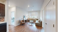 Located on Uptown Avenue in Broomfield, Colorado, this single-floor residence offers a thoughtfully designed layout with modern finishes throughout. The living area features warm wood-look flooring, recessed lighting, and a bright window with exterior views, creating a welcoming and comfortable atmosphere. A dedicated entryway with a built-in coat hook rail and seating provides a practical transition into the home.

The kitchen is well-equipped with rich dark wood cabinetry extending to the ceiling, black appliances including a refrigerator, range, microwave, and dishwasher, paired with light countertops and a decorative tile backsplash. The open layout allows for easy flow between the kitchen and living spaces.

The bedroom is carpeted and features a wide window that allows ample natural light and views of the surrounding area, complemented by a ceiling fan. A secondary room with carpet flooring and a sliding closet door offers flexibility as a guest room or home office.

The unit includes two bathrooms, each featuring dark wood vanity cabinetry with light countertops and a full shower-tub combination. The clean, neutral palette throughout the bathrooms contributes to the home's cohesive modern aesthetic. Overall, the residence presents a clean, functional, and comfortable living environment in Broomfield, CO.