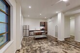 Located in the heart of New Orleans' Central Business District, this 2-bedroom, 2-bathroom unit at 234 Loyola Ave offers a well-organized single-floor layout designed for functional living. The open-concept living, dining, and kitchen area forms the heart of the space, featuring stainless steel appliances including a refrigerator, microwave, and range, complemented by warm wood cabinetry and a stainless steel prep island. Recessed lighting, ceiling fans, and track lighting illuminate the space throughout, while the distinctive mottled flooring adds an industrial character unique to the unit. Grid-paned windows in the living area and bedrooms allow natural light to filter in, enhancing the clean, white walls. Both bedrooms are comfortably sized, each equipped with ceiling fans, dedicated closets with shelving, and easy hallway access. The bathrooms are finished with light gray tile flooring, white subway tile walk-in showers with glass enclosures, and modern floating vanities with white countertops. A bonus room provides additional flexible space, and an impressive nine closets throughout the unit ensure exceptional storage. Hallways connect the rooms efficiently, contributing to a streamlined and practical floor plan.