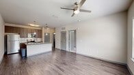 Located at 2509 Cattlemen Rd in Sarasota, FL, this one-bedroom, one-bathroom unit offers a thoughtfully designed open-concept layout across a single floor. The combined kitchen, dining, and living area serves as the heart of the home, highlighted by a central island with granite countertops, an undermount sink, and pendant lighting overhead. Rich, dark-toned cabinetry pairs with a full suite of stainless steel appliances — including a refrigerator, range, microwave, and dishwasher — while wood-style plank flooring and neutral walls create a clean, modern aesthetic. The living area is bright and airy, featuring a ceiling fan and multiple windows dressed with blinds that invite natural light. The spacious primary bedroom is carpeted for comfort, equipped with its own ceiling fan, and features two windows with outdoor views, a dedicated closet, and direct access to the full bathroom. The bathroom mirrors the design language of the kitchen with matching granite countertops, dark wood cabinetry, a tub-shower combination, and wood-style flooring. A dedicated laundry area adds everyday convenience. The unit's consistent use of neutral tones and modern finishes throughout gives the space a cohesive, contemporary feel.