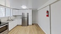 This single-story residence at 113 Bramble Wood, Lynchburg, VA, offers 610 square feet of efficiently designed living space. The home comprises three bedrooms, including a generous 200 square foot primary bedroom, one full bathroom, a kitchen, and a hallway. Throughout the property, wood-look flooring creates a cohesive and contemporary aesthetic. The kitchen is equipped with white cabinetry, stainless steel appliances, and a modern circular light fixture. The bathroom features a standard tub-shower combination with white tiled walls. Each bedroom is equipped with a window, allowing natural light to filter in, and closet space for storage. The property's compact layout maximizes functionality, with the kitchen area offering ample cabinet space and a comfortable cooking environment. Window-mounted air conditioning units provide climate control. The neutral color palette, predominantly in shades of white and light gray, contributes to a bright and open atmosphere throughout the home.
