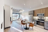 Located at 1600 Lauzon Rd in Windsor, Ontario, this thoughtfully designed one-bedroom, one-bathroom unit offers a well-utilized floor plan with modern finishes throughout. The open-concept kitchen, dining, and living area forms the heart of the unit, bathed in natural light streaming through large floor-to-ceiling sliding glass doors that lead to a private balcony with open city views. The kitchen is equipped with stainless steel appliances, including a French door refrigerator, electric range, built-in microwave, and dishwasher, complemented by two-tone cabinetry in warm wood and cool grey tones, a geometric patterned tile backsplash, and dark stone countertops. Exposed concrete columns and visible ductwork lend an industrial loft character to the living space, which features light hardwood-style flooring throughout. The bedroom offers elevated ceilings, a large window with exterior views, a sliding double-door closet, and ample natural light. The bathroom is finished with terrazzo-style flooring, a floating wood vanity, framed mirror, and a glass-enclosed shower. A dedicated laundry area completes this efficient and stylish unit.