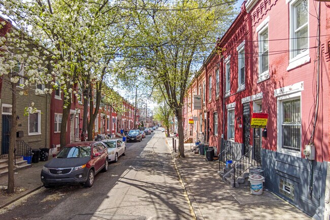 Two-story brick row homes with street parking are common throughout North Philadelphia West.
