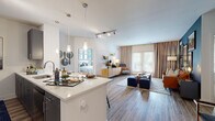 This single-floor residence at 350 Creamery Way in Exton, PA offers a well-designed open-concept layout that seamlessly connects the kitchen, dining, and living areas. The kitchen is appointed with gray flat-front cabinetry, stainless steel appliances, quartz countertops, a large peninsula with bar seating, and pendant lighting above — all flowing onto wood-style flooring that extends throughout the main living areas.

The living room is a standout space, featuring a bold navy accent wall adorned with a curated gallery of framed artwork, and French doors that open to the outdoors, allowing ample natural light. Striped curtains frame the doors, adding a classic touch to the contemporary design.

The two bedrooms offer plush carpeting and generous natural light through large windows with blinds. One bedroom features a dramatic dark accent wall with a grid of framed art, while the other presents a brighter, more neutral palette. Each bedroom connects to a bathroom finished with gray cabinetry and white quartz countertops. Walk-in closets with wire shelving provide practical storage solutions. The overall ambiance throughout is modern and cohesive, with thoughtful design details at every turn.