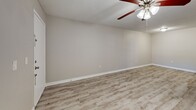 Located at 3706 W Idlewild Ave in Leto, FL, this one-bedroom, one-bathroom unit offers a practical and well-appointed layout across a single floor. The open-concept living, dining, and kitchen area forms the heart of the unit, finished with light wood-look luxury vinyl plank flooring and neutral-toned walls throughout. A ceiling fan with light fixture overhead serves both the living and dining areas, while a window allows natural light to fill the space. The kitchen features warm wood cabinetry, granite-style countertops, a peninsula with breakfast bar, and black appliances including a range, microwave, refrigerator, and dishwasher. A louvered closet door in the kitchen provides additional storage. The bedroom is carpeted for comfort, features a window with outdoor views, and is connected to a closet area. A second closet adds further storage convenience. In-unit laundry is also included. The bathroom is finished with tile-surround tub and shower combination, granite-top vanity with undermount sink, and matching wood-look flooring. A textured ceiling is consistent throughout the unit, adding a classic residential character to the overall design.